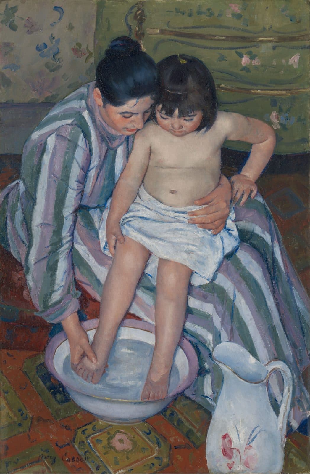 A mother washes her small daughter's feet in a basin, both looking down at the water
