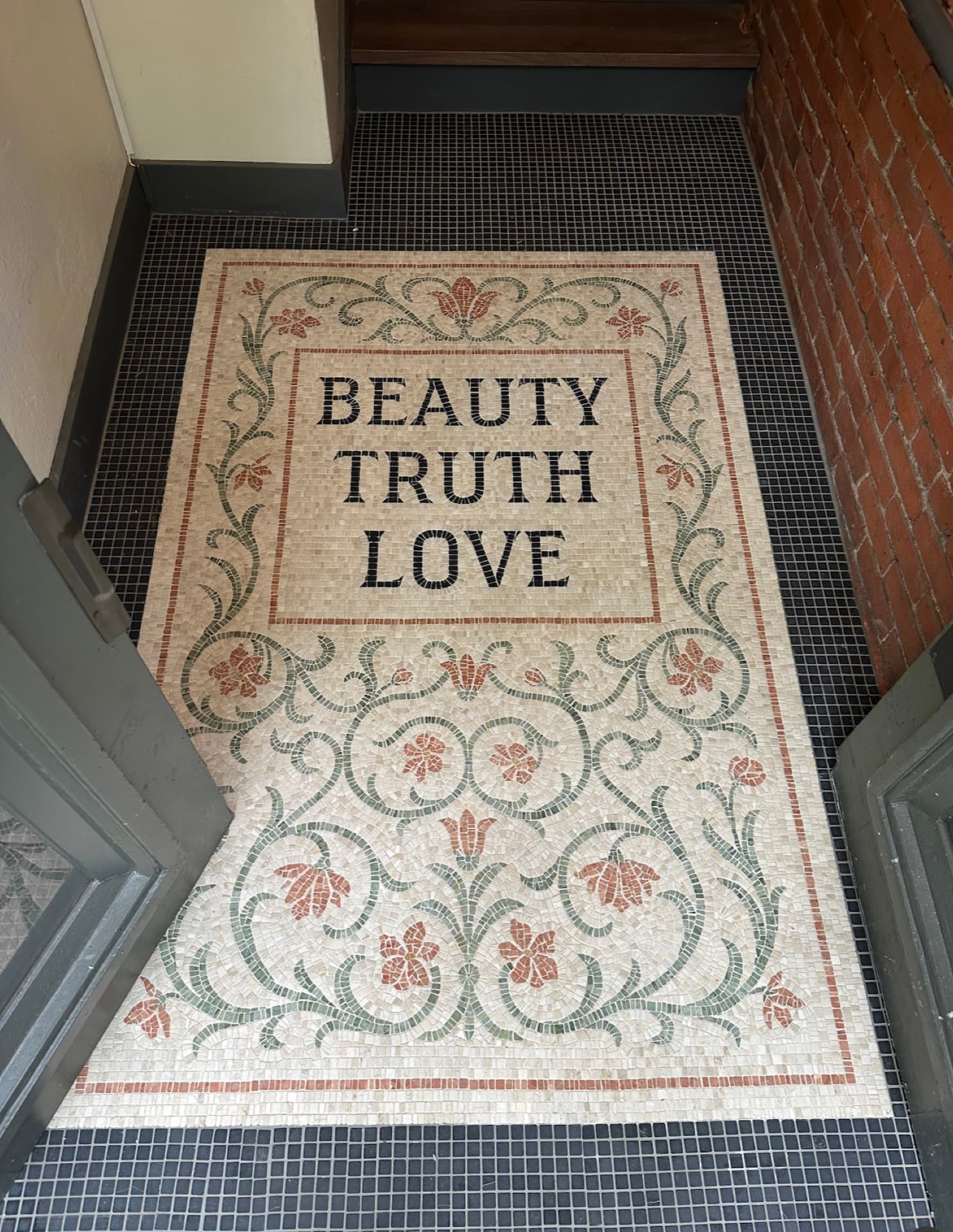 A mosaic floor inlaid with the words Beauty, Truth, Love at the Occidental's entrance